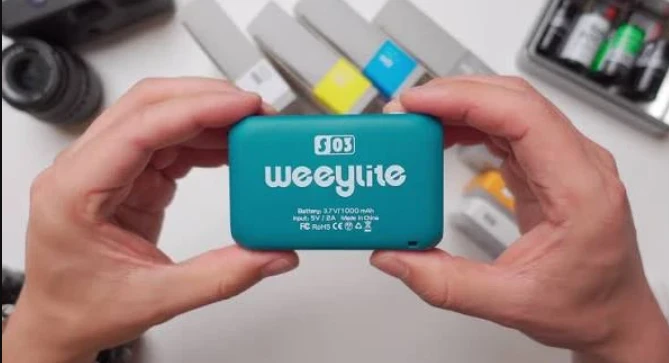 Бірюзова світлодіодна панель Viltrox Weeylite S03 у руках оператора, що демонструє плоску задню кришку без екрана та мініатюрний корпус